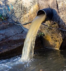 Landfill drainage pipe with wastewater pouring out.