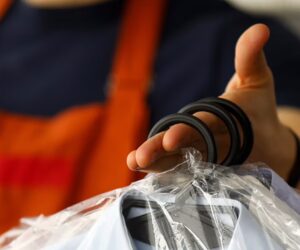 Dry Cleaners. Person holding dry cleaning items.